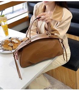Gros plan d'un sac en cuir marron avec logo PNAOTOR sur une table en marbre
