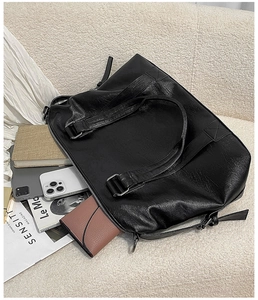 Top view of large black PU leather tote bag showing spacious interior with tablet and books