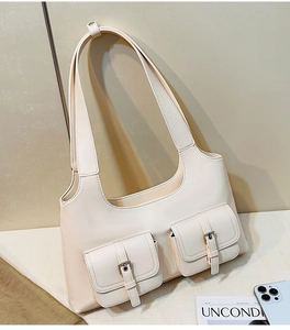 Detailed close-up of cream PU leather shoulder bag featuring dual pockets and silver buckles