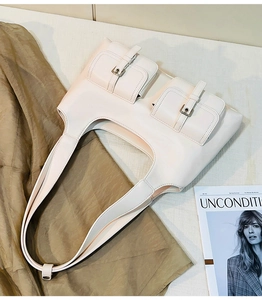 Detail of retro cream shoulder bag featuring double front flap pockets and metal buckles
