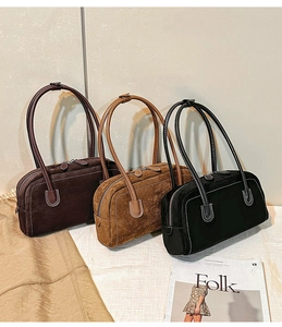 Close-up of matte suede shoulder bags with contrast stitching and slim straps