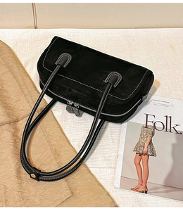 Detailed top view of black suede shoulder bag featuring contrast stitching and zipper