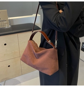 Detail showing the brown vintage matte suede texture and leather strap of the shoulder bag