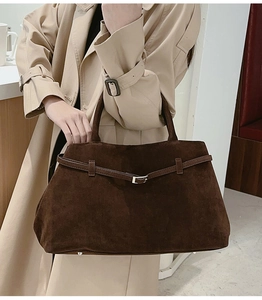 Détail de la boucle en métal argenté et de la sangle sur le sac cabas marron foncé