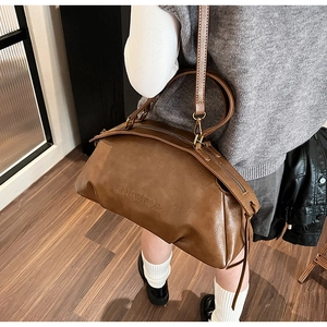 Vue détaillée du sac bowling en cuir marron avec lettrage embossé et fermeture éclair