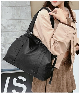Close-up of black lychee grain tote bag showing durable PU leather and metal zipper detail