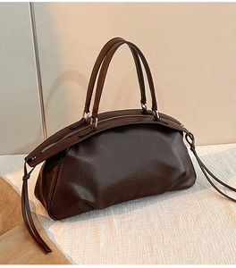 Gros plan d'un sac à main vintage marron foncé avec de longs détails de franges en cuir