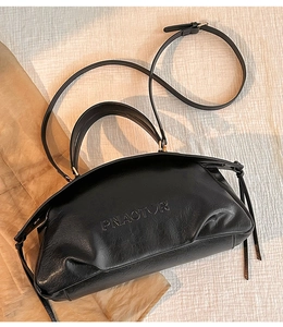 Gros plan d'un sac en cuir noir avec logo embossé et bandoulière réglable pratique