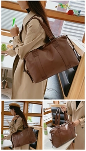 Detail of reinforced stitching and adjustable side straps on a large brown leather bag