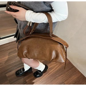 Gros plan du sac à main en cuir marron foncé avec logo embossé PNIAOTOR et détail de gland