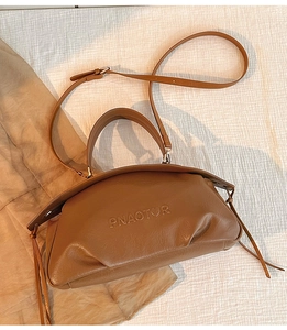 Détail d'un sac boulette plissé marron montrant le cuir et le logo en relief