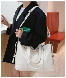 Detailed view of large white lychee-pattern tote bag worn as a shoulder crossbody bag