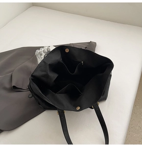 Interior view of large black tote bag showing spacious compartments and magnetic closure