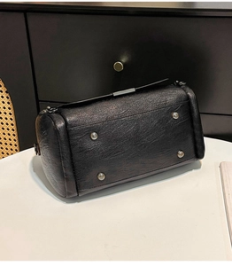 Dettaglio dei piedini in argento e della pelle martellata sulla base della borsa nera