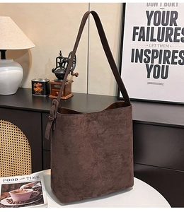 Detail shot of a large brown suede tote bag with a wide adjustable strap for daily commute