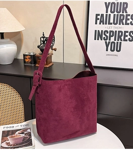 Detail shot of burgundy suede tote bag with adjustable strap and square buckle detail