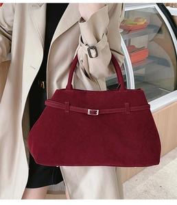 Détail du cabas en daim bordeaux avec boucle argentée et décoration de sangle élégante