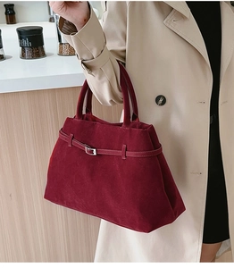 Sac fourre-tout bordeaux élégant à texture mate et boucle porté par un mannequin