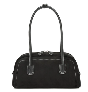 Close-up of black matte leather shoulder bag with white contrast stitching and double zippers