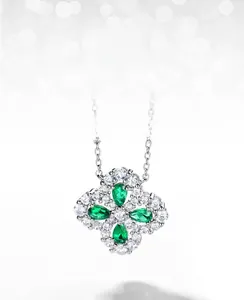 Detailed macro of S925 silver four-leaf clover pendant with pear-cut emerald gemstones