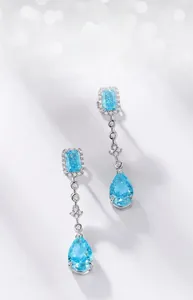 Macro detail of S925 silver drop earrings with light blue pear-cut stones and pavé set diamonds