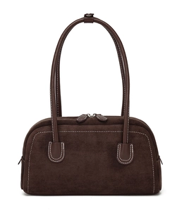 Detail of dark brown suede shoulder bag featuring contrast white stitching and top zipper