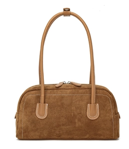 Detail view of brown suede shoulder bag featuring tan leather straps and white contrast stitching