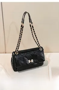 Detail of black quilted chain bag with gold-tone twist lock and woven leather strap