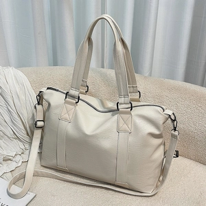 Minimalist beige pebble leather tote bag with dual handles and dark metallic hardware
