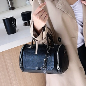 Classica borsa Boston in morbida pelle nera con un elegante ciondolo a piuma metallica