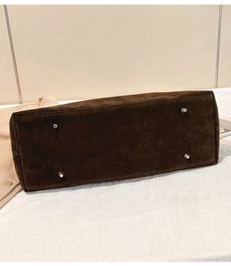 Vue détaillée du fond du grand sac cabas avec quatre pieds en métal et coutures précises