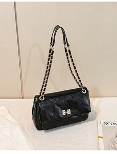 Detail of black quilted chain bag with gold twist lock and glossy PU leather texture