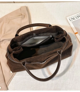 Vue détaillée du dessus d'un grand sac cabas en daim marron foncé avec compartiment