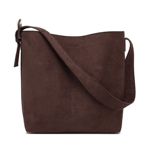 Brown frosted suede bucket tote bag with wide shoulder strap in minimalist design