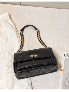Detail of black quilted chain bag featuring a gold twist lock and elegant texture