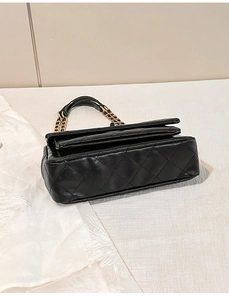 Detailed view of black quilted faux leather crossbody bag with golden chain strap