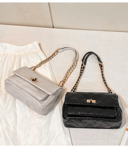 Detail of quilted leather texture and metal chain straps on stylish crossbody bags