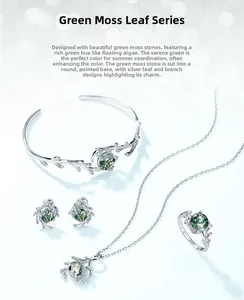 Macro shot of green moss agate jewelry set featuring intricate silver leaf branch designs