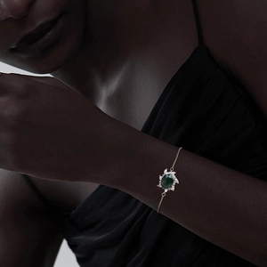 Detail of rose gold sunburst bracelet with green moss agate gemstone on wrist