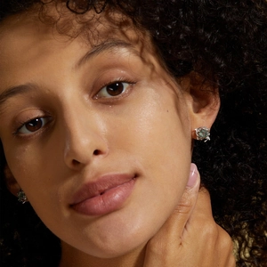 Macro close-up of S925 silver stud earrings with green moss agate on a female model
