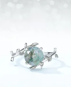 Close-up of moss agate ring with adjustable branch-shaped band and green gemstone