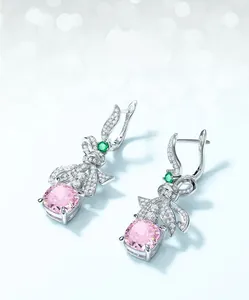 Gros plan sur boucles d'oreilles nœud en argent S925 avec diamant rose et pierre verte