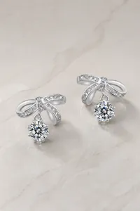 Macro detail of silver bow drop earrings with sparkling moissanite stones