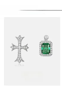 Detail of S925 silver cross earring and emerald-cut green gemstone with micro-pave setting