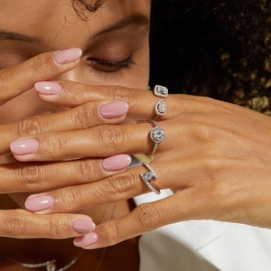 Close-up of sparkling moissanite silver rings with emerald, pear, and round cuts