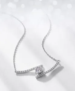 Macro detail of round moissanite pendant in bezel setting on a fine silver chain
