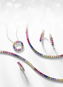 Detailed set of S925 silver jewelry with rainbow cubic zirconia on a soft bokeh background