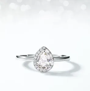 Macro shot of pear cut moissanite ring with halo setting and adjustable band detail