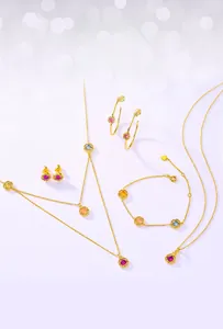 Flat lay of double-layer gold necklaces and colorful gemstone jewelry set on purple background