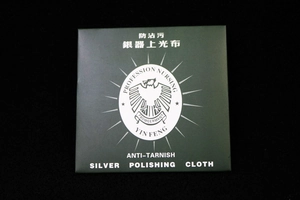 Detail of dark green packaging for jewelry polishing cloth with eagle logo brand